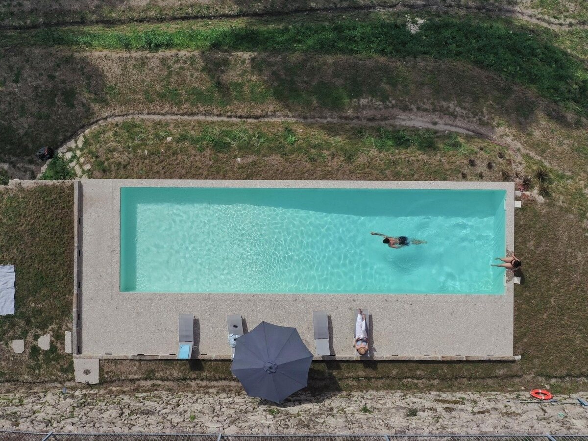 Vista aérea da piscina rodeada de relva