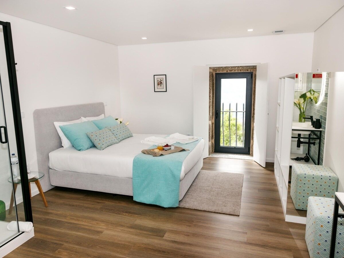 Suite luminosa com porta para varanda e casa de banho aberta