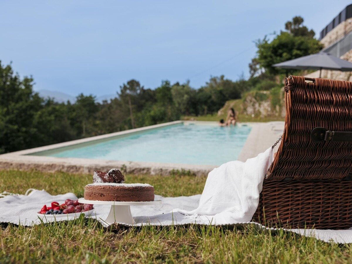 Piquenique com bolo de chocolate na relva junto à piscina
